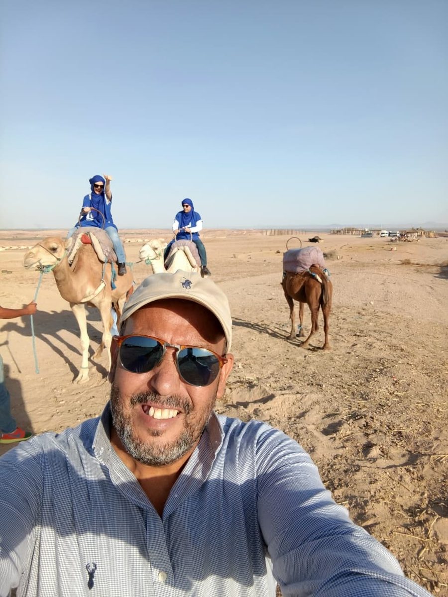 Abdelaziz, founder of Beldia Tours, with travelers on a camel trek